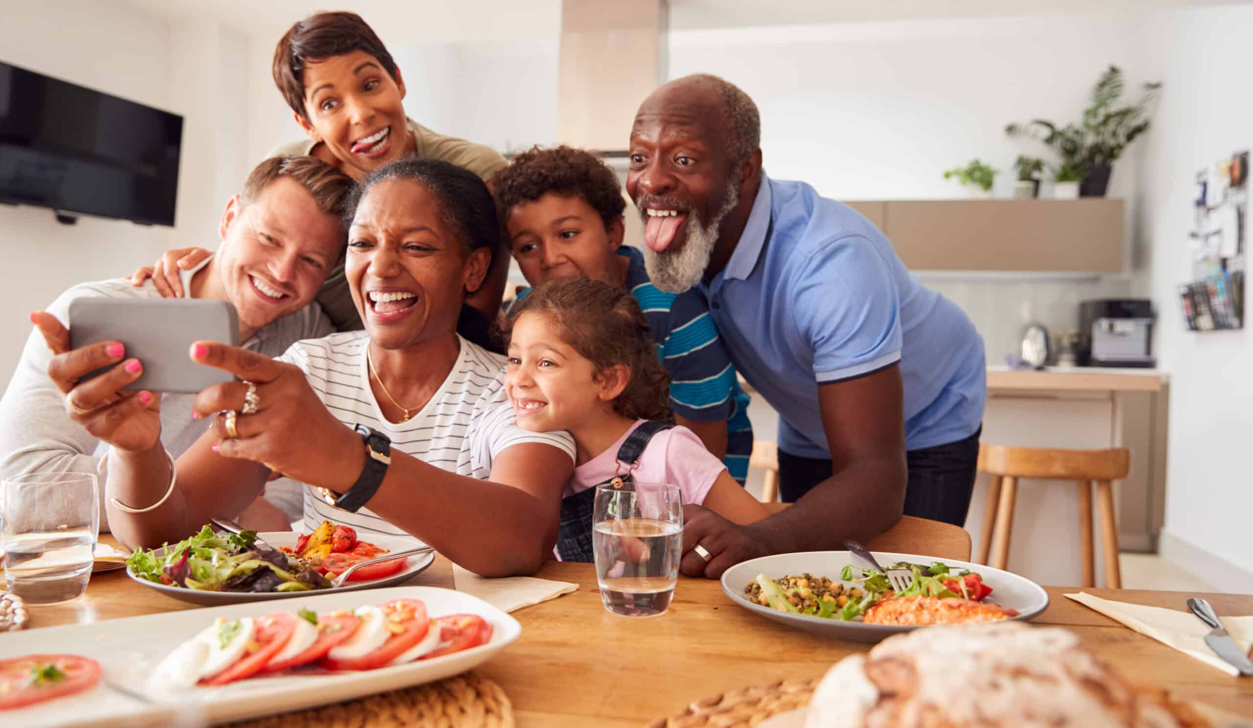 Family taking a selfie at the dinner table.